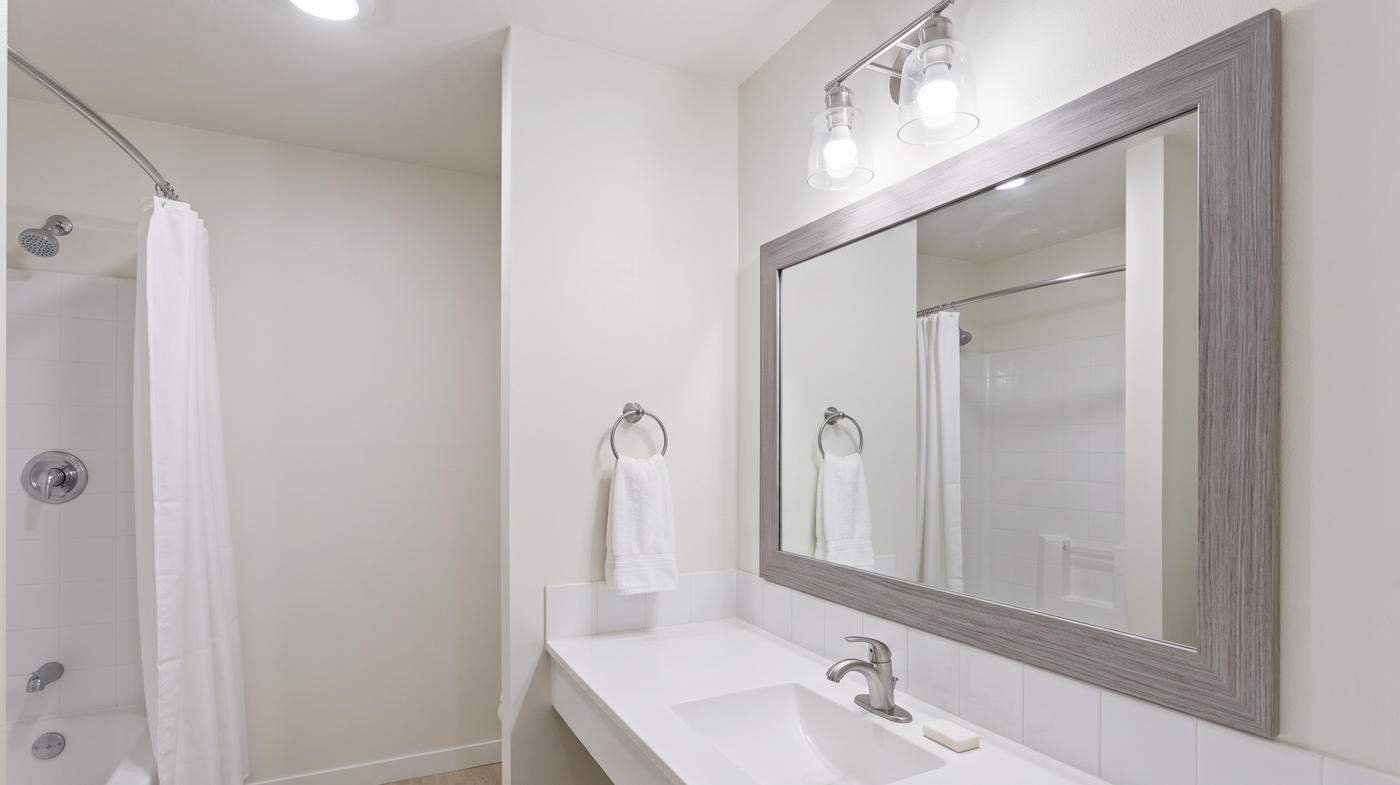 Existing bathroom mirror upgraded with a made-to-order frame in a renovated property