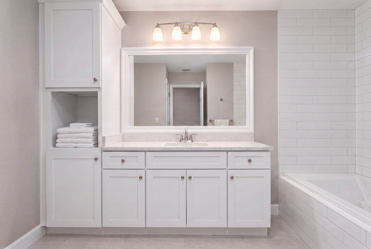 Updated apartment bathroom with a framed mirror installed during a rental unit turn