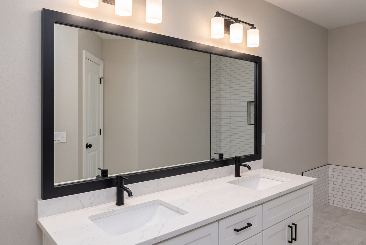 Professionally remodeled bathroom with a newly installed framed vanity mirror